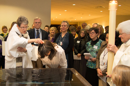 Denise, sponsors and the Sunday Assembly community gather at the baptismal font for Denise's baptism
