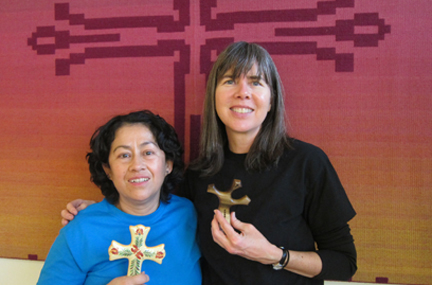 Sojourners Paz and Denise standing together holding their favorite crosses